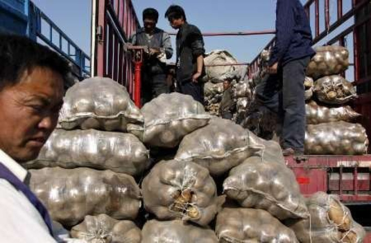 Customers purchase potatoes from a vegetable market located on the outskirts of Beijing.  