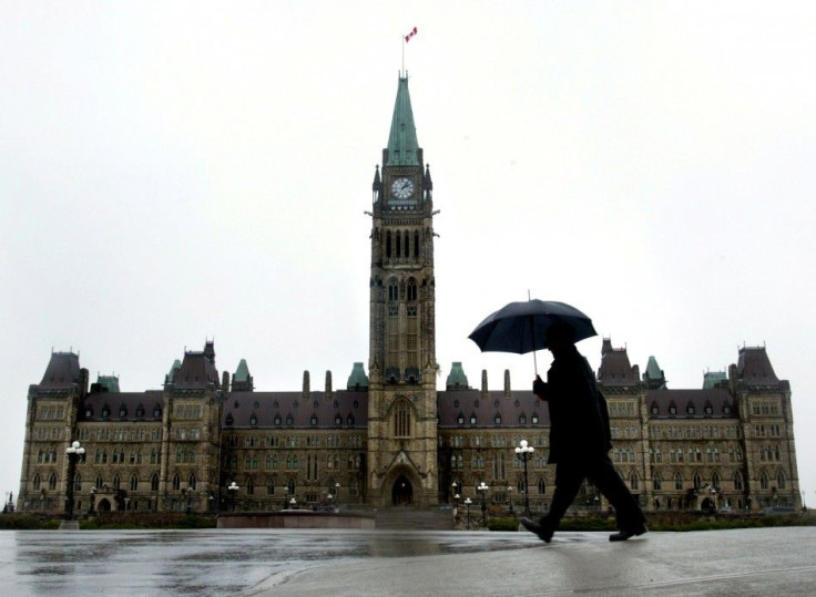 A pedestrian walks in the rain on Parliament Hill in Ottawa, November 13, 2003. [Canadian Prime Mini..