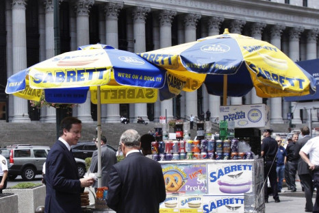 British PM David Cameron buys a hot dog with New York City Mayor Michael Bloomberg outside Penn Station in New York
