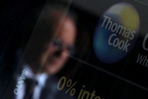 A pedestrian is reflected in the window of a branch of travel agent Thomas Cook in London