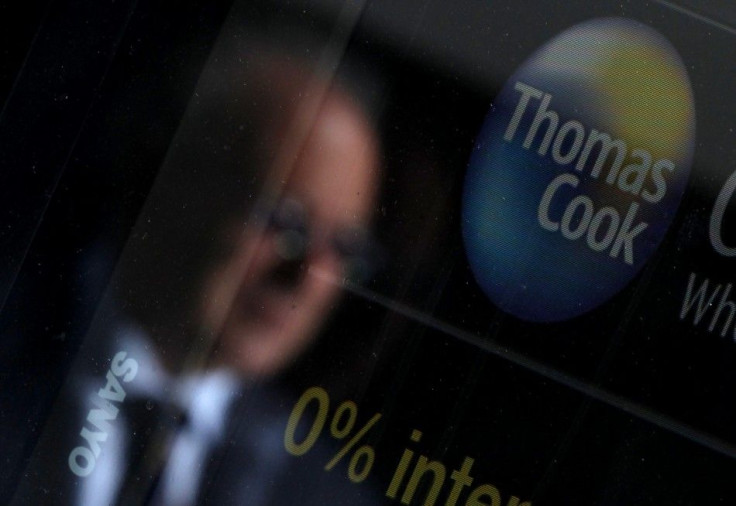 A pedestrian is reflected in the window of a branch of travel agent Thomas Cook in London