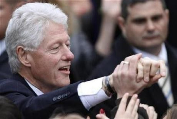 Former U.S. President Bill Clinton is greeted by audience as he arrives to deliver a speech at the anti-AIDS action 'Fight for Future' in Kiev, October 3, 2010.