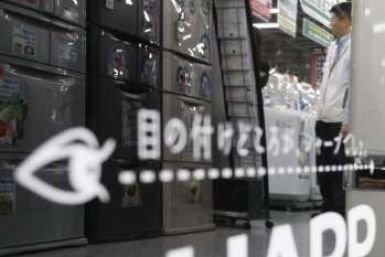A man is reflected on Sharp's logo on its fridge at an electronic shop in Tokyo October 29, 2009. 
