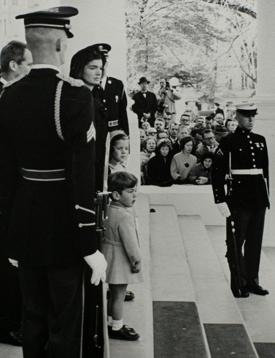 President John F. Kennedys widow, Jacqueline Bouvier Kennedy, stands with their young son John F. Kennedy Jr. and daughter Caroline.