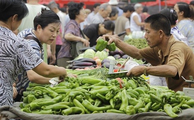 Customers select vegetables at a market in central Beijing, August 11, 2010.