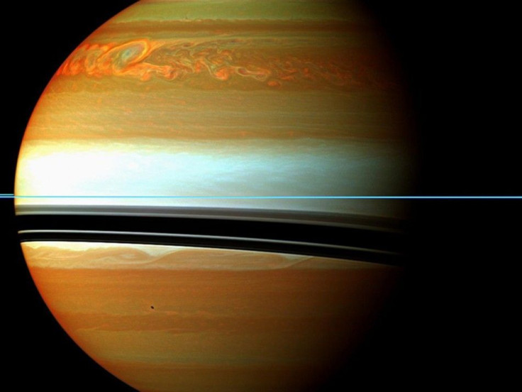 NASA handout image shows Saturn's atmosphere and its rings in a false color composite made from 12 images, captured on January 12, 2011. The mosaic shows the tail of Saturn's huge northern storm