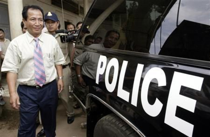 Cambodian radio station director Mam Sonando (front on L) walks towards a police vehicle after being questioned at Phnom Penh Municipality Court, in this file picture taken October 11, 2005. A Cambodian court jailed Sonando, a 71-year-old radio broadcaste