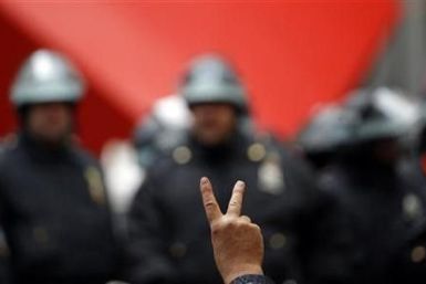 An Occupy Wall street protestor gestures in front of New York City Police inside Zuccotti Park as protests moved through the streets of lower Manhattan near the New York Stock Exchange during what organizers called a &#039;&#039;Day of Action&#039;&#039; 