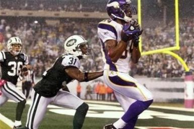 Minnesota Vikings' wide receiver Randy Moss catches a touchdown pass from quarterback Brett Favre in the second half of their NFL football game against the New York Jets in East Rutherford, New Jersey, October 11, 2010. 