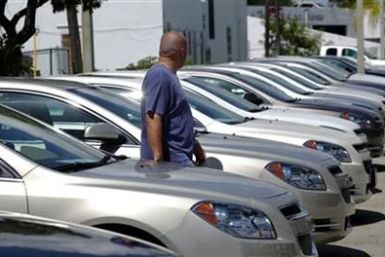 A man walks next to Chevrolet vehicles at a GM dealership in Miami