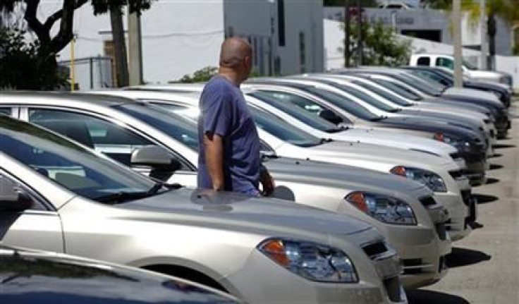 A man walks next to Chevrolet vehicles at a GM dealership in Miami