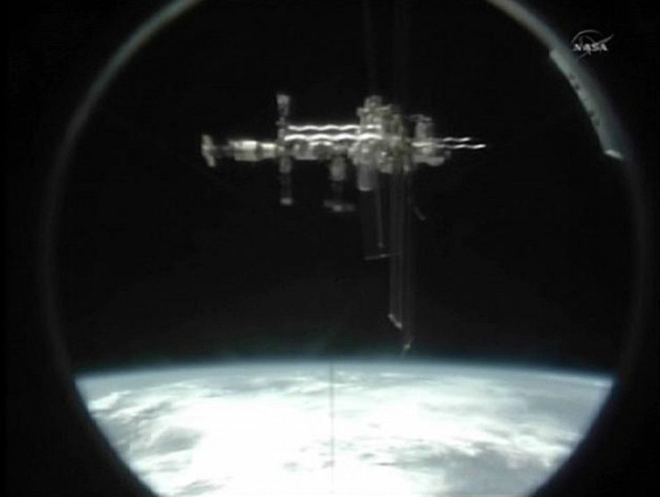 The International Space Station is seen through the docking port of the U.S. space shuttle Atlantis as it departs the station in this still image taken from NASA TV 