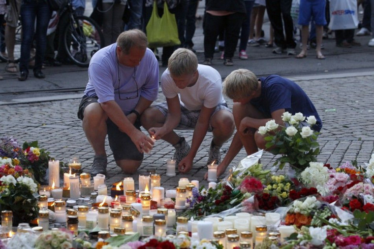 People light candles as they mourn for the victims of the massacre on an island in the countryside and the bomb blast in the capital Oslo