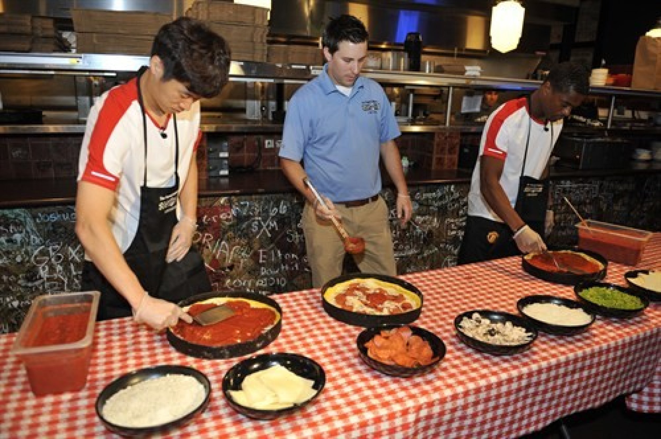Patrice Evra and Park Ji-Sung have a go at making pizzas at Ginos East in Illinois.