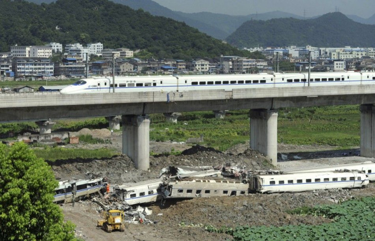 A high speed bullet train runs past a railway bridge past carriage wreckage (below) after two trains crashed and derailed in Wenzhou, Zhejiang province July 25, 2011. China sacked three senior railway officials on Sunday after a collision between two high