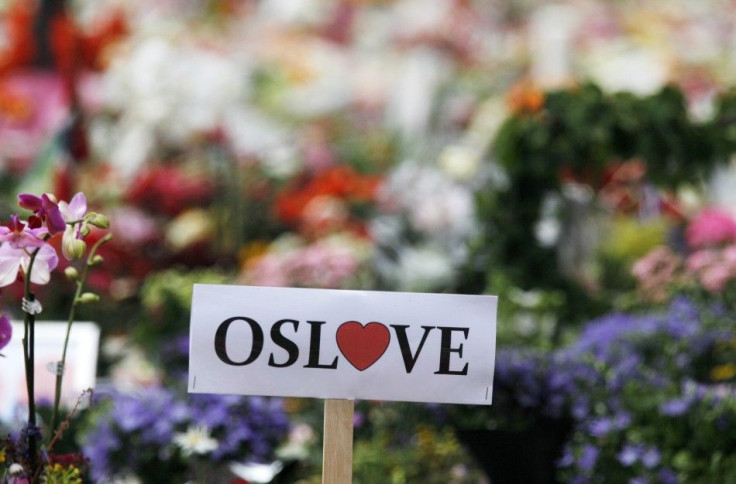 A sign of love for Oslo is seen inside of a sea of flowers and lit candles placed in memory of those killed in Friday's bomb and shooting attack in front of Oslo Cathedral