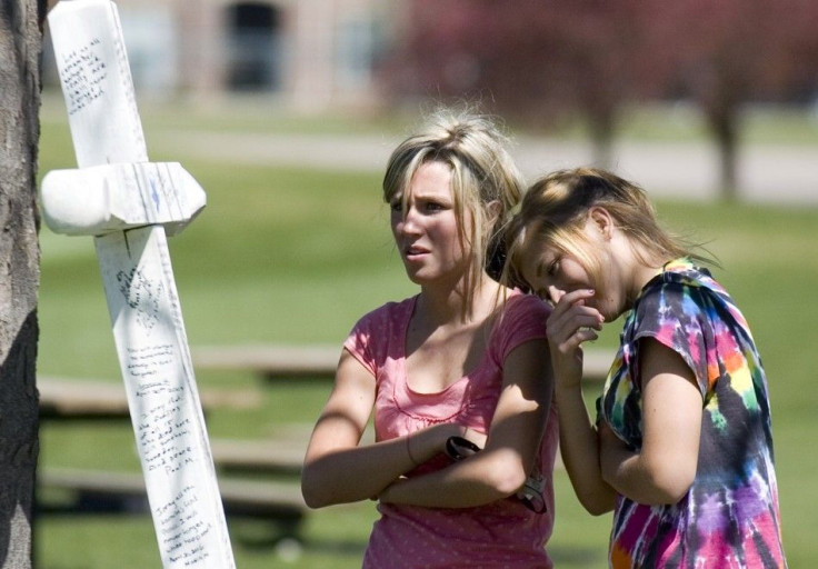 Alyssa Nikolas and Kailey Bucher read messages written to victims of the 1999 shooting at Columbine High School in Clement Park in Littleton