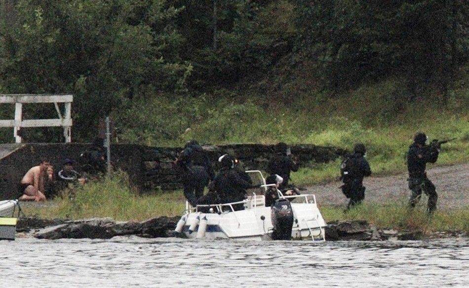 People watch as members of Norwegian Special Forces land by boat on the shore of the island of Utoeya
