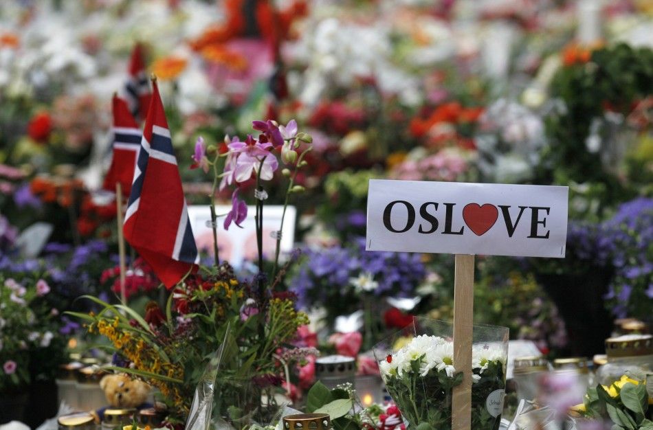 A sign of love for Oslo is seen inside of a sea of flowers and lit candles placed in memory of those killed in Fridays bomb and shooting attack in front of Oslo Cathedral