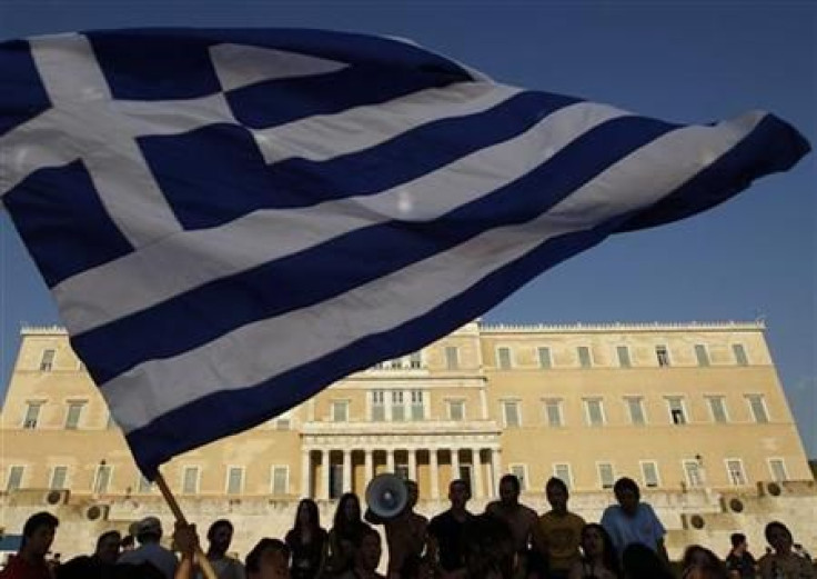 Protesters raise a Greek flag in front of parliament during a rally in Athens' Syntagma square