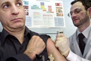 Dr. Stephen Friedman (R) vaccinates his colleague Dr. Don Weiss