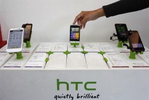 A shop attendant arranges HTC phones in a mobile phone store in Taipei