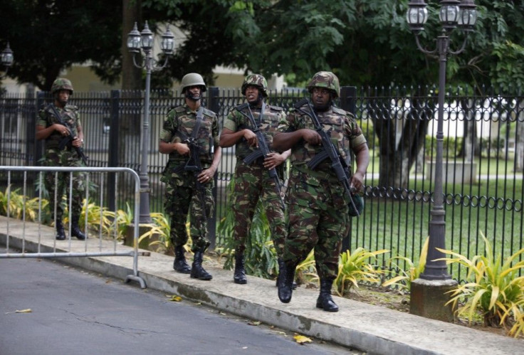 Trinidad and Tobago soldiers patrol the residence of Prime Minister Kamla Persad-Bissessar after her news conference in Port of Spain