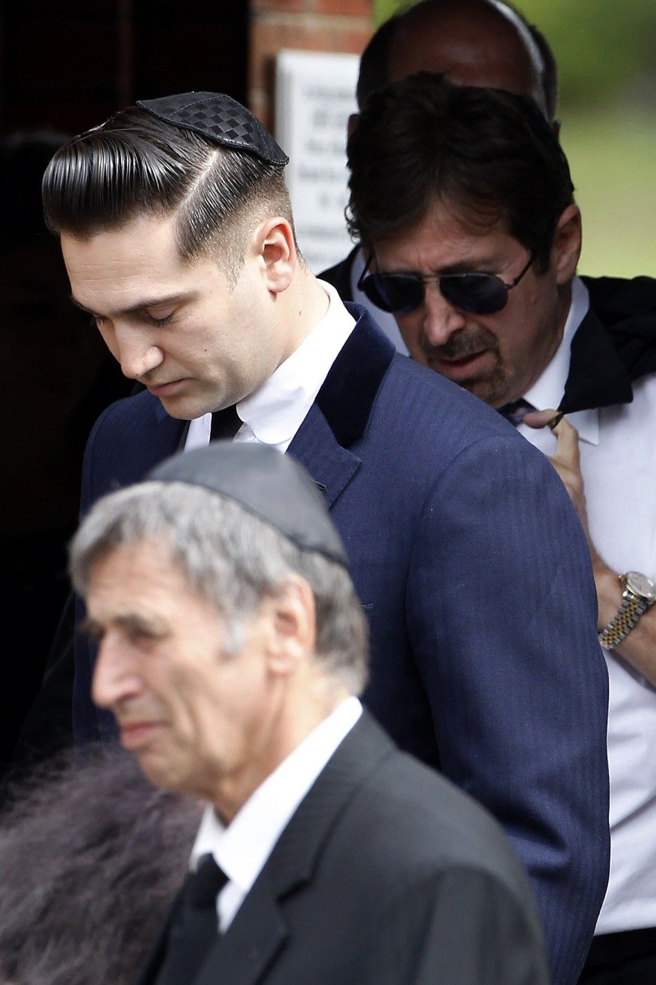 Reg Traviss, the former boyfriend of deceased British singer Amy Winehouse, leaves after her funeral at Golders Green Crematorium in north London 