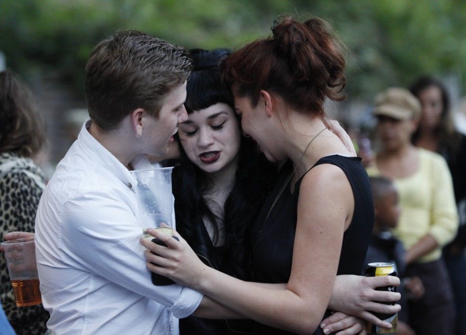 Fans embrace outside the house of British singer Amy Winehouse, following her funeral earlier in the day, in north London July 26, 2011. The funeral of British singer Amy Winehouse was held on Tuesday after an autopsy failed to pinpoint the cause of her d