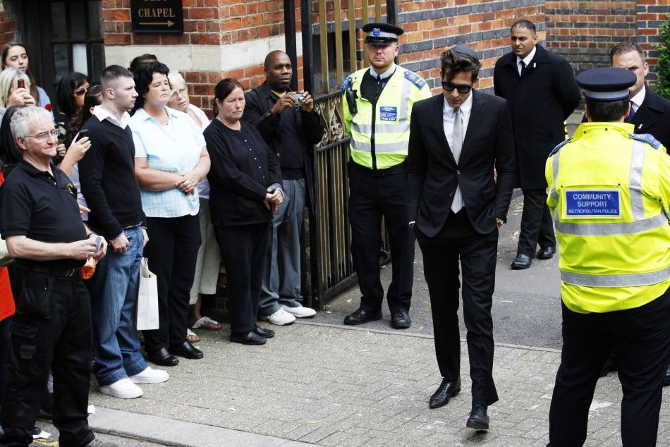 Music producer Mark Ronson C walks past members of the public as he leaves Golders Green Crematorium after the funeral of British singer Amy Winehouse, in north London 