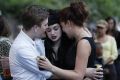 Fans embrace outside the house of British singer Amy Winehouse, following her funeral earlier in the day, in north London
