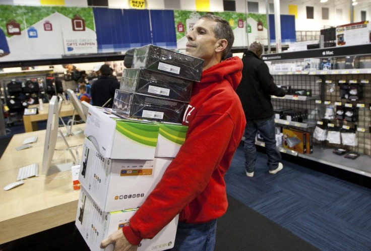 A customer holds an armload of electronics as he waits to check out at a Best Buy store in Pineville, North Carolina