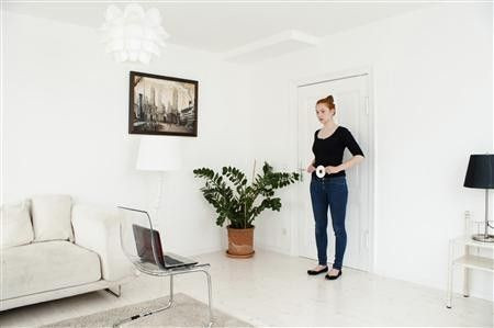A model holds a cd as a reference point as her webcam enabled laptop photographs her body as part of the UPcload service in this publicity photo released to Reuters November 25, 2011. Using a webcam and the company's website, a user's body is ph
