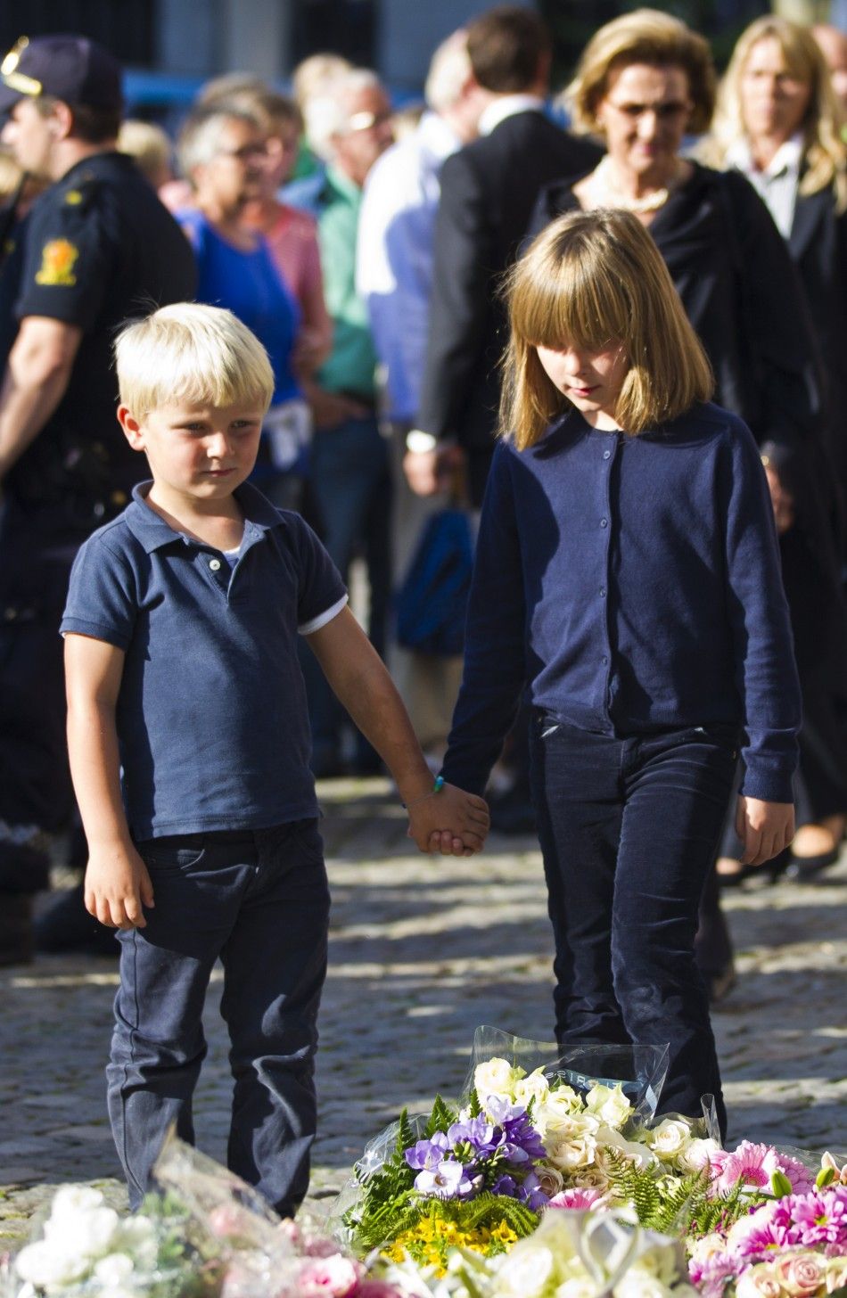 Norways Prince Magnus and Princess Alexandra hold hands during a candle lighting ceremony in tribute to the victims of Fridays twin attacks at Oslo Cathedral