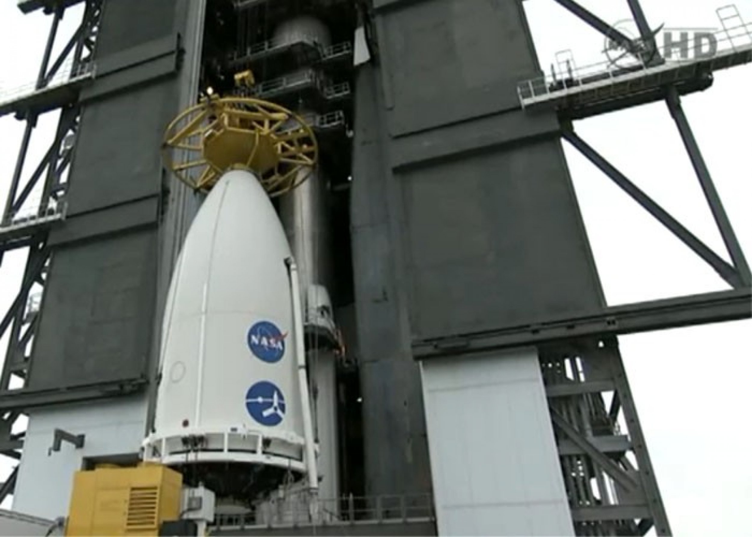 Jupiter probe Juno, which rests inside a part of Atlas V rocket, is being hoisted up the launch pad