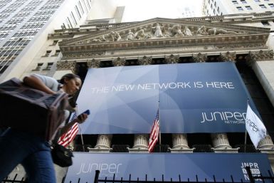 A woman walks past a banner with the logo of Juniper Networks Inc. covering the facade of the New York Stock Exchange 29/10/2009