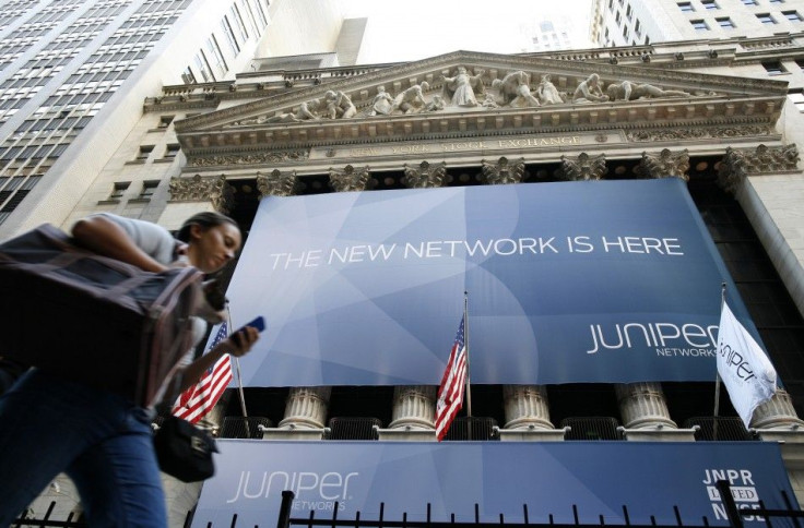 A woman walks past a banner with the logo of Juniper Networks Inc. covering the facade of the New York Stock Exchange 29/10/2009
