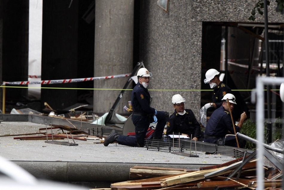 Police investigators work in front of destroyed government building in Oslo