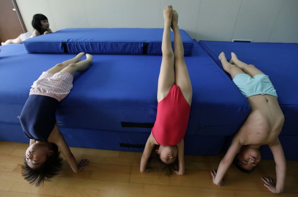 Children practise doing handstands before a diving training session at a training centre in Beijing