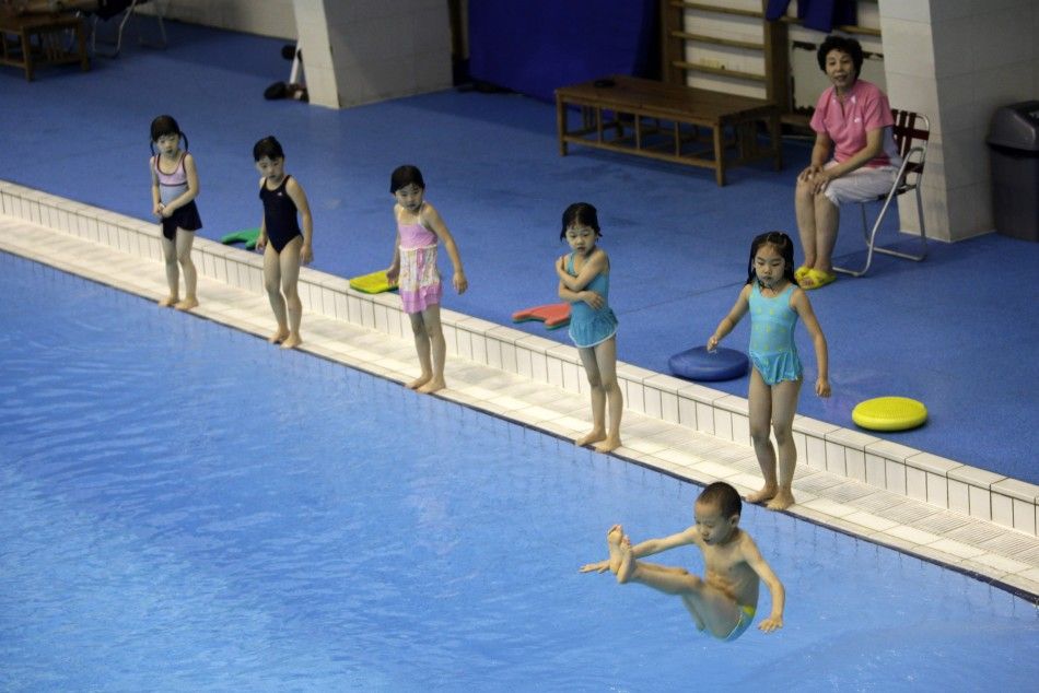 Children practise jumping into a pool during a diving training session at a training centre in Beijing