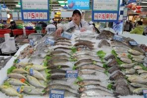 A shop assistant arranges fish for sale at a supermarket in Hangzhou, Zhejiang province January 14, 2011.