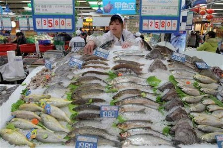 A shop assistant arranges fish for sale at a supermarket in Hangzhou, Zhejiang province January 14, 2011.