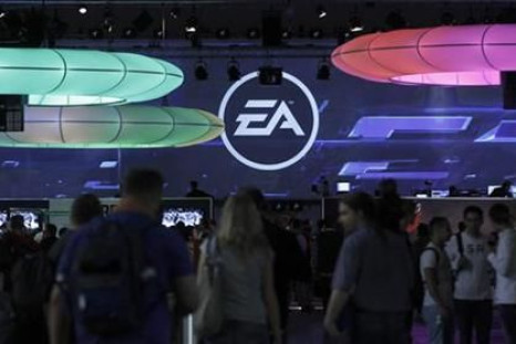 Visitors walk past the exhibition stand of Electronic Arts at the Gamescom 2010 fair in Cologne