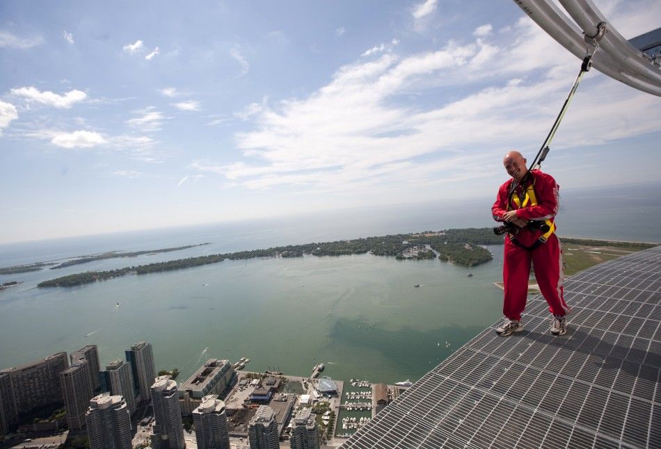Photographer Mark Blinch works on the catwalk during the media preview for the quotEdgewalkquot on top of the CN Tower in Toronto