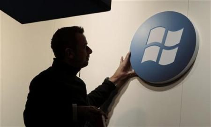 A worker adjusts a logo on the Microsoft stand at the CeBIT computer fair in Hanover