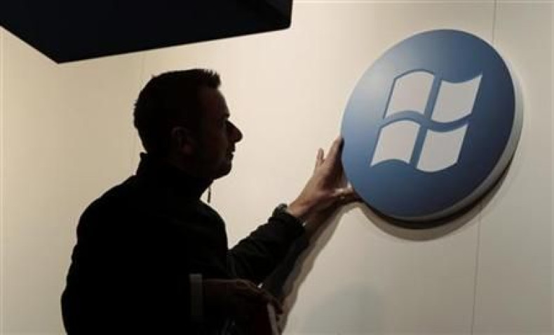 A worker adjusts a logo on the Microsoft stand at the CeBIT computer fair in Hanover