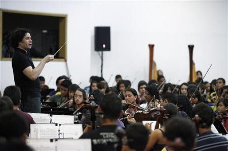 Simon Bolivar Youth Orchestra conductor Gustavo Dudamel leads the orchestra for a performance during a visit by conductor Daniel Barenboim at the venue of the National System of Children and Youth Orchestras of Venezuela in Caracas August 11, 2010.