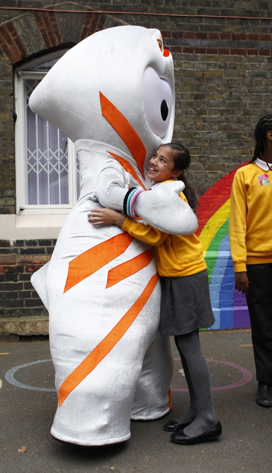 The 2012 Olympic mascot Wenlock hugs a student