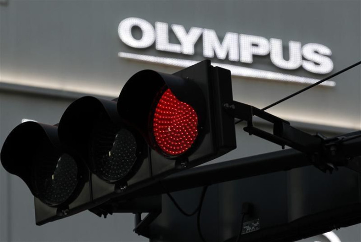 A logo of Olympus Corp is seen behind a traffic signal outside of an electronic shop in Tokyo