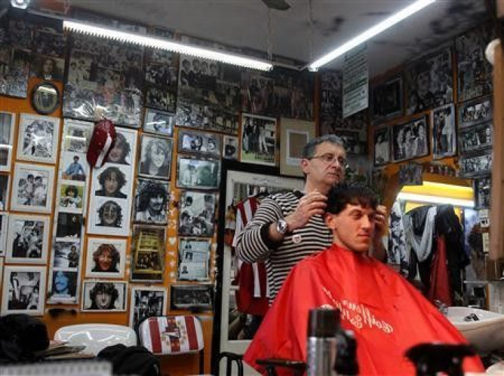 Hairstylist Gerardo Weiss cuts a customer&#039;s hair at his hairdressing saloon